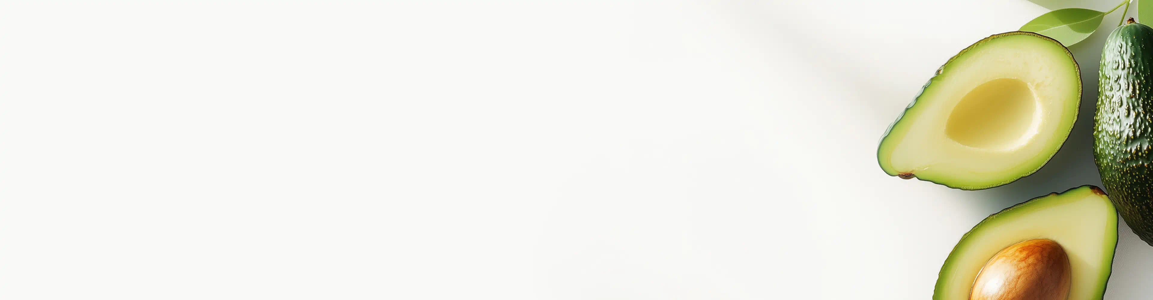 Whole and halved avocados with green leaves