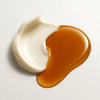 Rich brown oil and smooth white cream swirled together on a light background