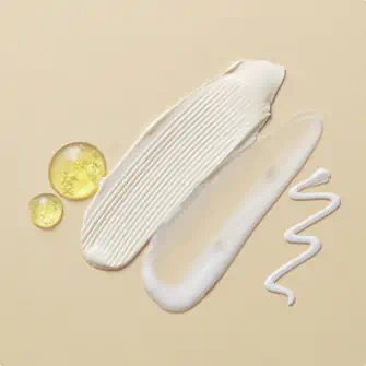 Swatches of cream, lotion, gel, and oil on a beige surface