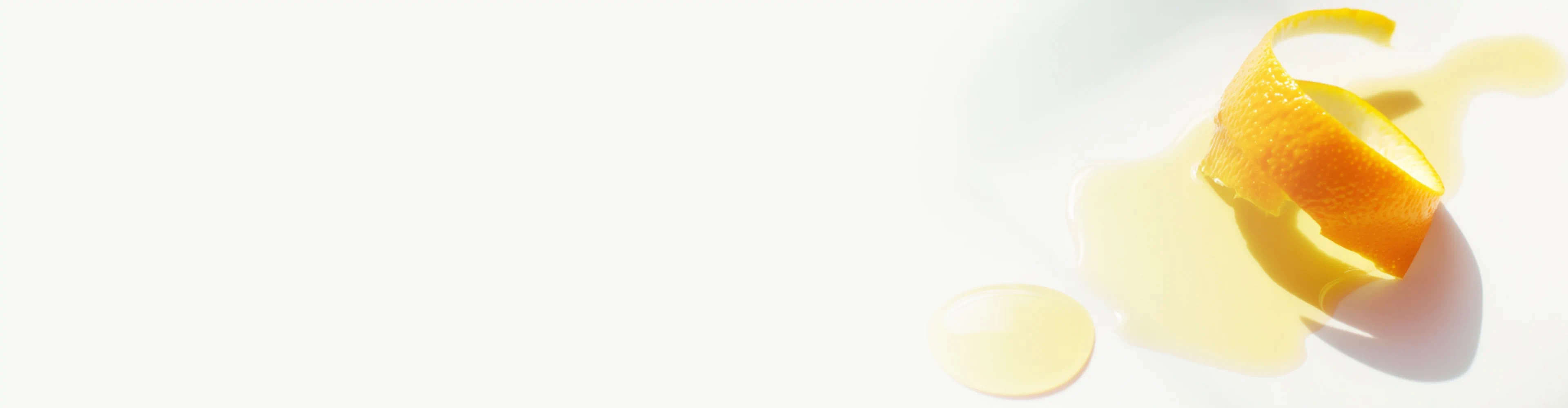 Orange peel curl beside a glossy pool of oil