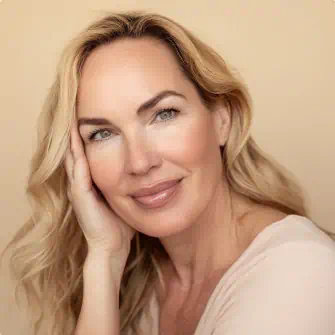 Blonde woman with glowing skin smiling softly